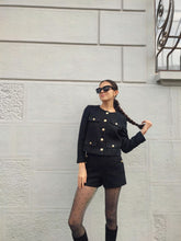 A lady wears a cropped jacket.